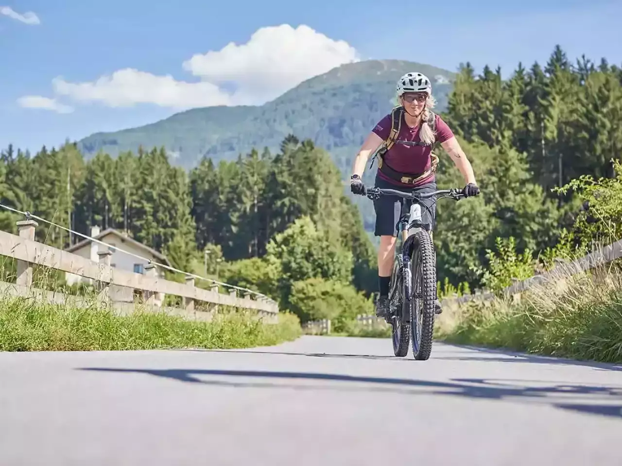 Frau mit E-Bike fährt durch den Wald