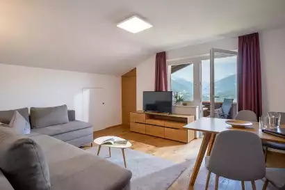 1_tiroler-alpenhof-patsch-fewo-brennerspitz_wohnraum-aussicht_c_hannes-dabernig.webp