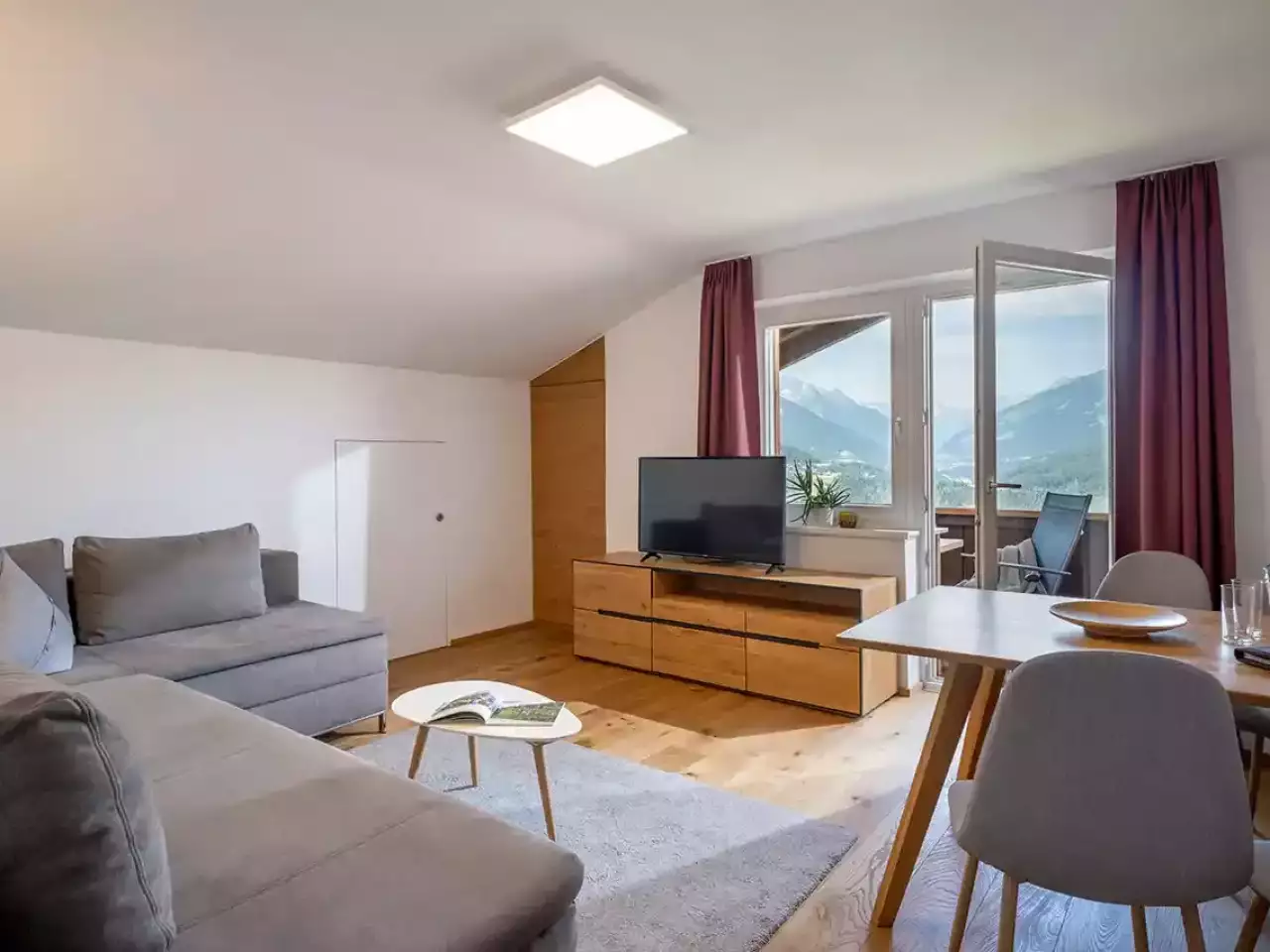 Apartment Wohnzimmer mit Sofa, TV, Esstisch und Balkon
