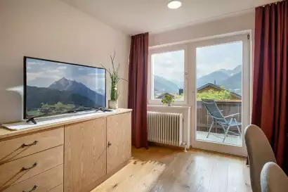 2_tiroler-alpenhof-patsch-fewo-habicht_wohnzimmer-mit-balkon_c_hannes-dabernig.webp